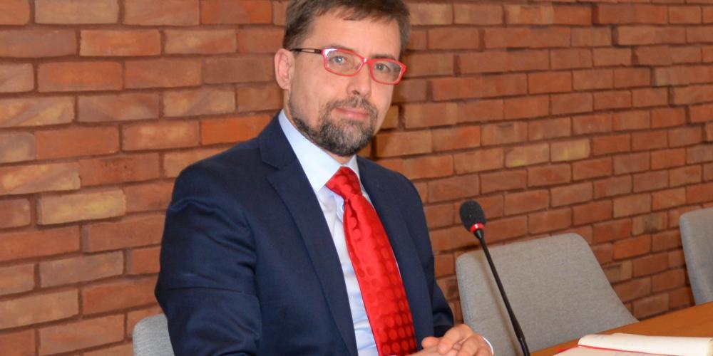 Burmistrz na tle ściany z czerwonej cegły.
