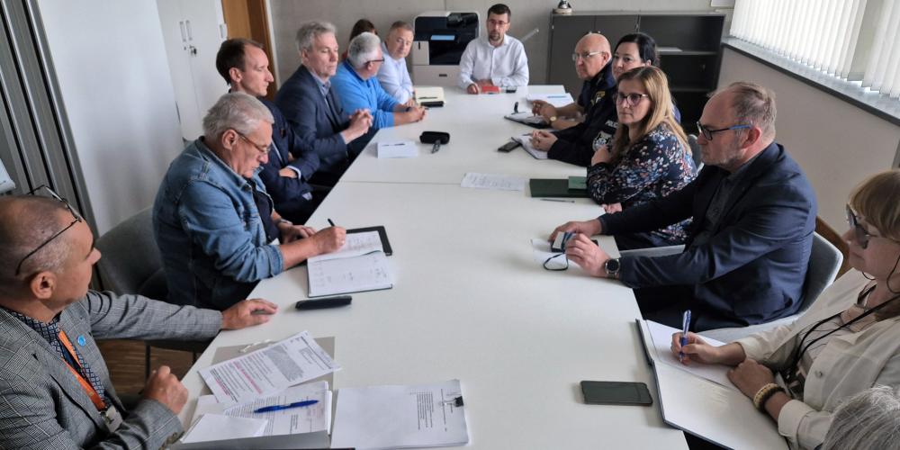 Grupa osób siedzi przy stole. 