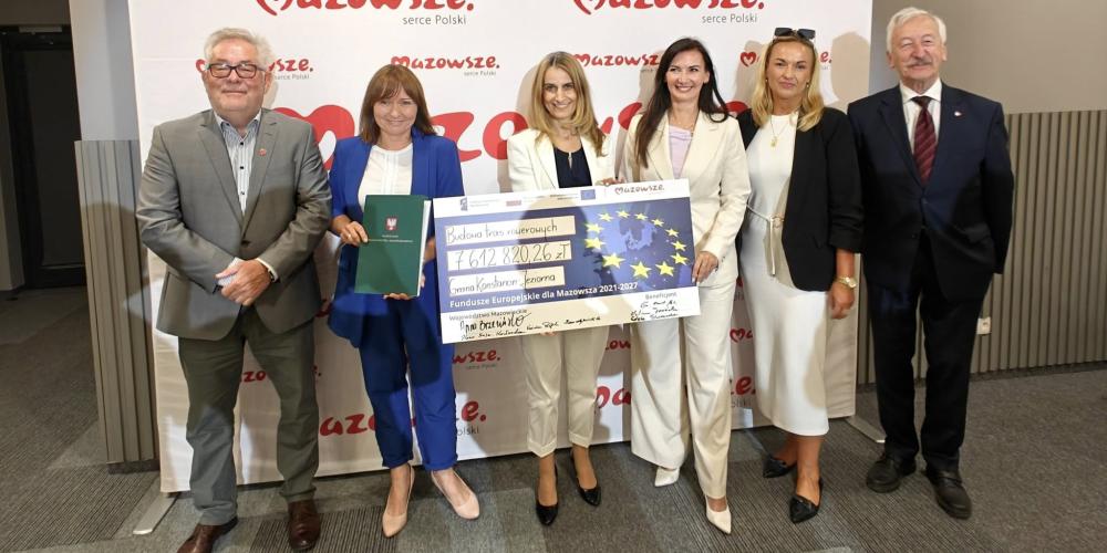 Grupa ludzi trzyma czek
