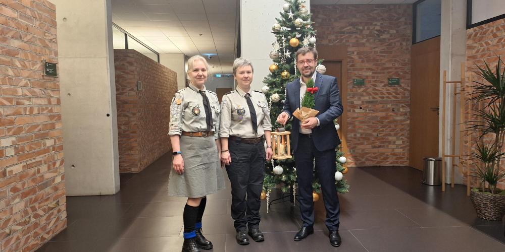 harcerki oraz burmistrz stoją w korytarzu ratusza trzymając zapalony drewniany lampion