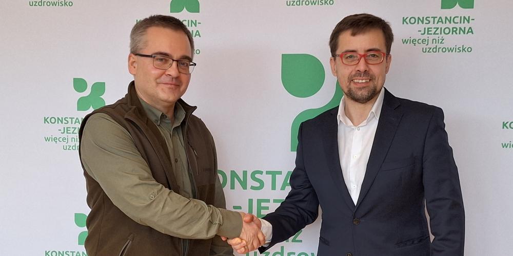 Dwie osoby podają sobie rękę z gratulacjami