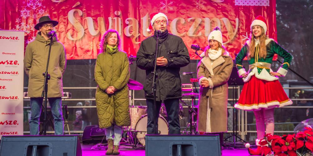 Grupa osób stoi na scenie i składa życzenia mieszkańcom