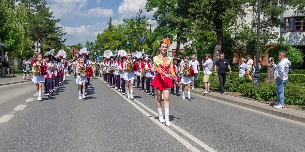 Parada z udziałem orkiestry i mażoretek przemierza ulicę podczas miejskiego święta w Konstancinie-Jeziornie.