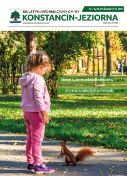 Dziewczynka w wieku przedszkolnym stoi na chodniku. Ubrana jest w różową bluzę i różowe spodnie i fioletowe buty. Naprzeciwko niej stoi ruda wiewiórka. W tle Park Zdrojowy.
