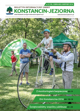 Park. Chłopiec w wieku szkolnym siedzi na rowerze starego typu z jednym wielkim kołem z przodu i małym kołem z tyłu. Obok stoi młody mężczyzna ubrany w białą koszulę i szare spodnie. Trzyma on kierownicę roweru i siodełko. Za rowerem stoi młody mężczyzna. W tle zielone namioty z napisem Konstancin-Jeziorna.