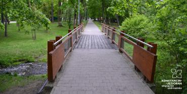 Drewniany mostek w parku, pośrodku nowe deski mostku i barierki po obydwu stronach, zdjęcie ilustrujące opisaną w artykule sytuację