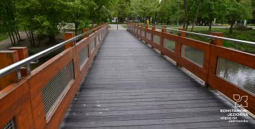 Drewniany mostek w parku, widoczne nowe deski i odremontowane barierki, zdjęcie ilustrujące opisaną w artykule sytuację