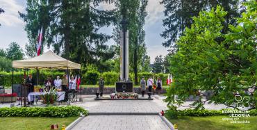 roczystości kościelne na Cmentarzu Powstańców Warszawy w Powsinie. W głównej części widać namiot, pod którym ksiądz odprawia msze. Do około stoją ludzie. 