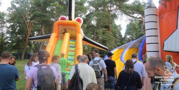 Park Zdrojowy. Dwie duże dmuchane zabawki ze zjeżdżalniami. Na nich bawią się dzieci. Przed zabawkami stoją osoby dorosłe.