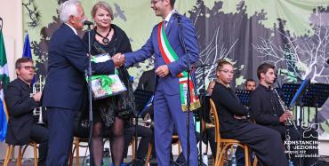 Burmistrz Kazimierz Jańczuk na scenie ściskający dłoń burmistrzowi Pisogne.