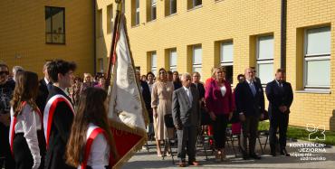 Fotorelacja z otwarcia szkoły w Słomczynie. Grupa osób przed szkołą.