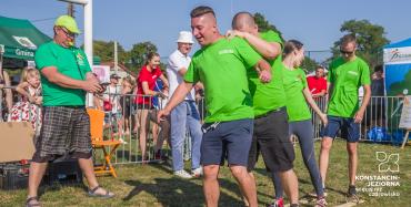 grupka osób ubrana w zielone koszulki uczestniczą w sportowej konkurencji