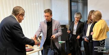 Grupa osób stoi w sali urzędu podczas świątecznego spotkania, w trakcie którego wręczane są podziękowania członkom Rady Seniorów.