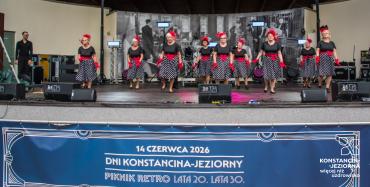 Seniorki wykonują układ taneczny w strojach inspirowanych modą retro.