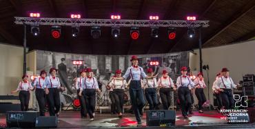 Grupa taneczna prezentuje choreografię w biało-czerwonych strojach na scenie amfiteatru.