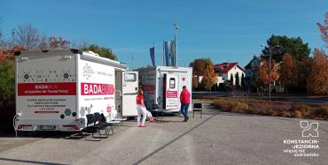 Przed urzędem stoją dwa mobilne gabinety medyczne oznaczone napisem „Badabus”, przy których znajdują się pracownicy oraz krzesła dla oczekujących pacjentów.