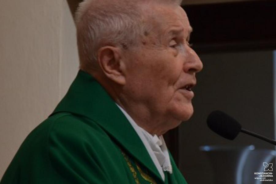 Starszy mężczyzna w stroju księdza, mówiący, ujęcie z prawego profilu