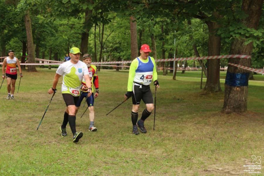 Several nordic walking people in the park, around the trees with trsa strips 
