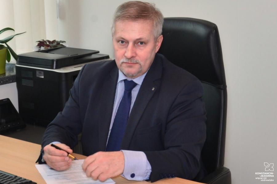 Pierwszy zastępca burmistrza gminy Ryszard Machałek siedzi przy biurku w ręku trzyma długopis.