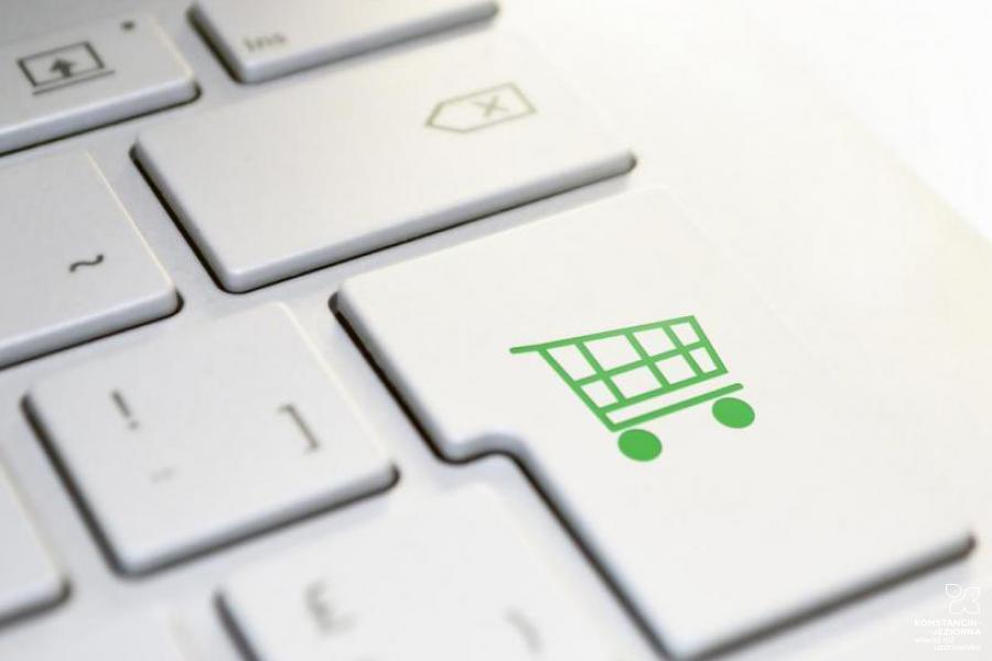 Fragment klawiatury komputerowej, na jednym z przycisków zielona grafika przedstawiająca wózek sklepowy na zakupy.