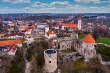 Widok z lotu ptaka miasta ze starą zabudową, na pierwszym planie budowla sakralna z wysoką wieżą, w tle widoczne fragmentu budowli zamkowej