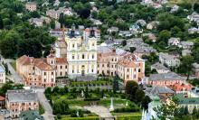 Widok z lotu ptaka na historyczną część miasta Krzemieniec, widoczne stare budynki, z kolorowymi elewacjami. Przestrzeń wypełniają grupy drzew. 