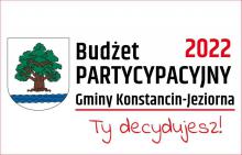 Grafika. Z lewej strony herb gminy: tarcza herbowa jest biała. Widnieje na niej drzewo – dąb – z brązowym korzeniem i pniem oraz zieloną koroną. Pod drzewem znajduje się pięć błękitnych fal symbolizujących rzekę Jeziorkę. Z prawej strony napis Budżet partycypacyjny Gminy Konstancin-Jeziorna 2022, Ty decydujesz!