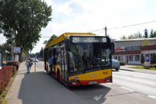 Ulica. Przy przystanku obok chodnika stoi żółto-czerwony autobus komunikacji miejskiej. Z przodu na górze jest napis 251 Metro Wilanowska. Do autobusu wsiada mężczyzna. Chodnikiem idą dwie kobiety.