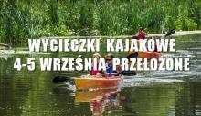 Po rzece płyną cztery osoby trzema kajakami. Kobieta i mężczyzna siedzą w jednym kajaku. Za nimi płynie dwóch mężczyzn. Wszyscy ubrani są w kamizelki ratunkowe, w rękach trzymają wiosła. Na zdjęciu duży biały napis wycieczki kajakowe odwołane