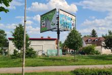 Przestrzeń miejska. Przy ulicy stojący billboard reklamowy. 