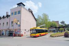 autobus na tle budynku, na ścianie ślady po zdemontowanych reklamach