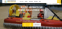 Zdjęcie pontonu ratowniczego stojącego na plaży. Na nim środku tekst: Budżet Obywatelski Powiatu Piaseczyńskiego 2023.
