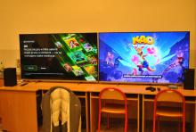 Włączone telewizory ustawione na stole, z wyświetlonymi na ekranie grami dla dzieci.