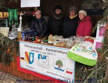 Zdjęcie stoiska z herbem Konstancina-Jeziorny, Za lada cztery kobiety. Na ladzie artykuły spożywcze.