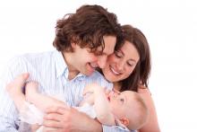 Rodzicie: kobieta i mężczyzna trzymają noworodka na rękach