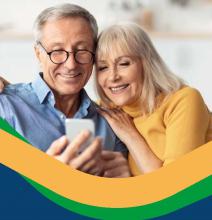 Para seniorów: kobieta i mężczyzna patrzą razem na ekran telefonu
