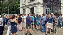 Grupa osób stoi przed budynkiem willi Kamilin