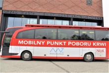 Autobus krwiodawca zaparkowany przed magistratem.  