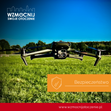 Dron z kamerą nad polaną, w tle drzewa