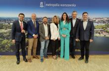 Grupa osób na tle ścianki promocyjnej z napisem metropolia warszawska 