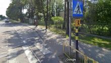 Fragment ulicy z chodnikiem, w tle przystanek autobusowy