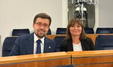 Dwie uśmiechnięte osoby w sali senackiej.