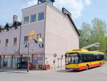 autobus na tle budynku, na ścianie ślady po zdemontowanych reklamach