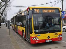 Żółto-czerwony autobus linii 710 komunikacji miejskiej, stojący na przystanku z widocznym kierunkiem Os. Kabaty.