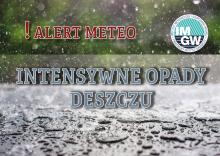 Intensywne opady deszczu. Na górze czerwony napis ! Alert meteo. W tle las i wzburzona tafla wody.