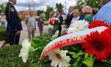 Zdjęcie reprezentantów samorządu składającego kwiaty przed pomnikiem powstanców.