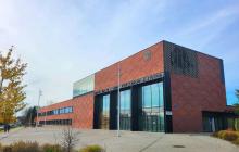 Budynek jednopiętrowy z czerwonej cegły i płaskim dachem.