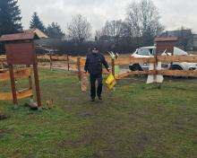 Strażnik miejski niosący reklamówi w darami.