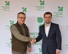 Dwie osoby podają sobie rękę z gratulacjami