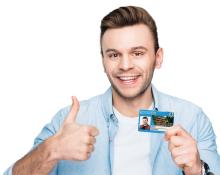 Uśmiechniety mężczyzna trzyma kartę mieszkańca i trzyma kciuk w górę.